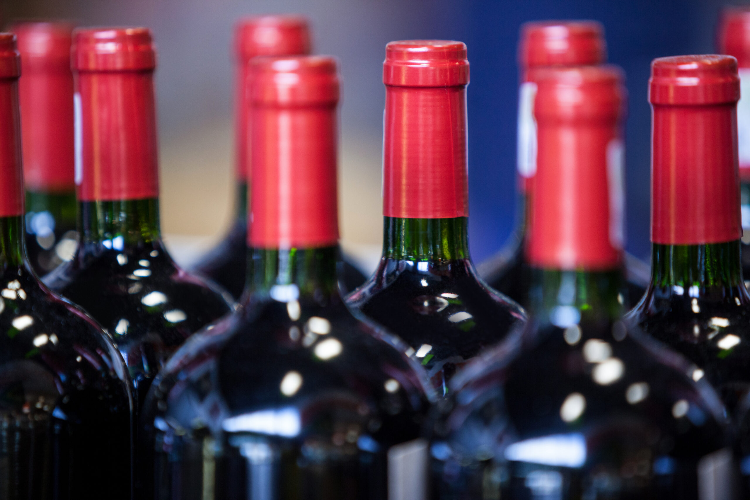 Close-up of wine bottles with red foil wrapping.