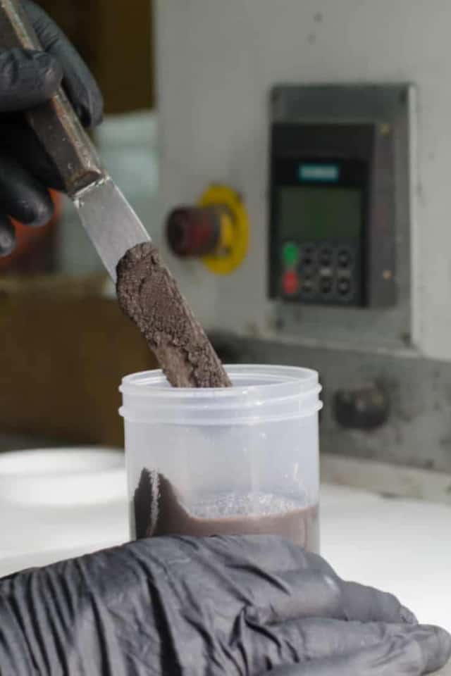 Person mixing brown pigment.